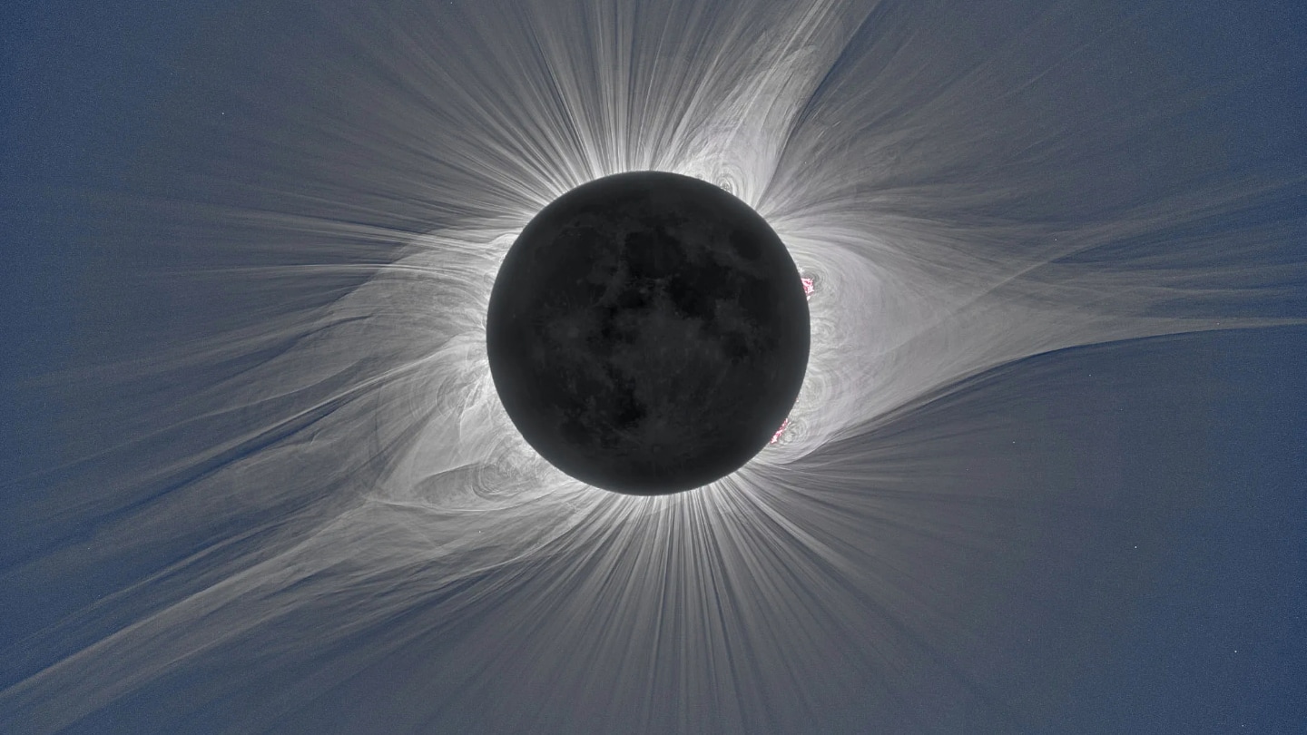 White emissions in the solar corona frame a moon with many shadows during a solar eclipse